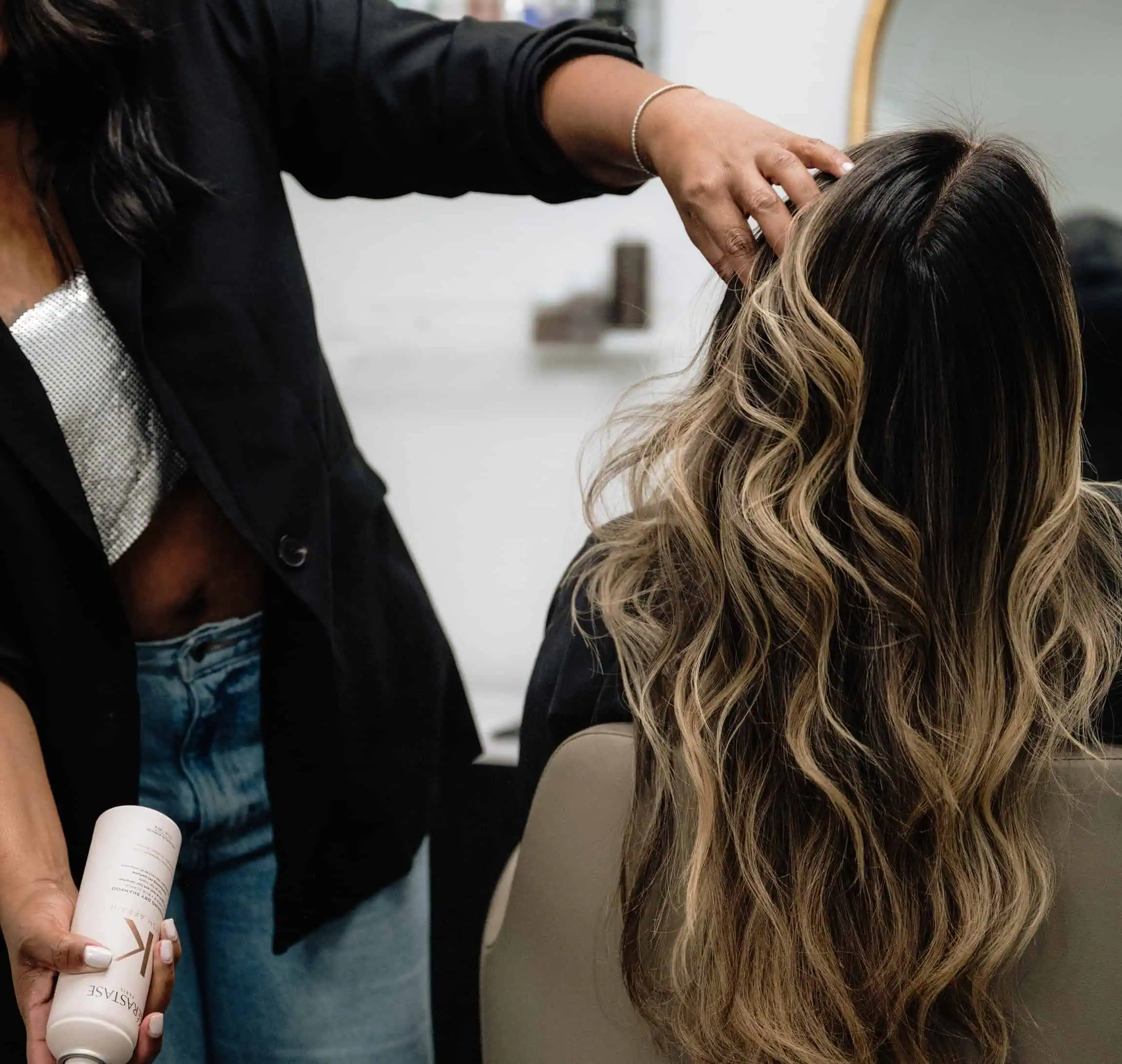 Stylist styling long blended hair at The Label Salon in Longwood, FL